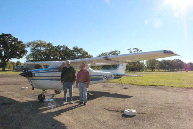 Photo of students by a training aircraft