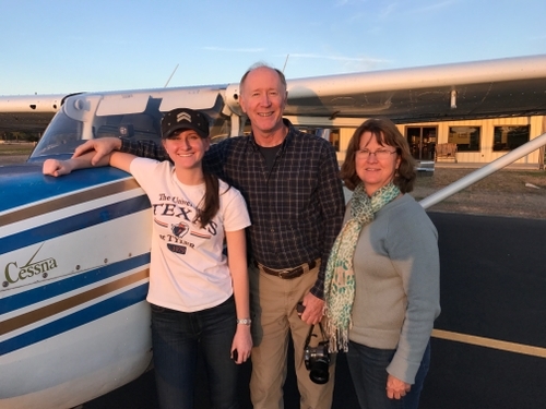 Photo of a student and their family by her training arcraft